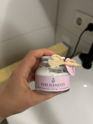 Zufriedene Kundin zeigt Anti-Aging Tagescreme von Pure Elements – aufgenommen im natürlichen Licht eines Badezimmers